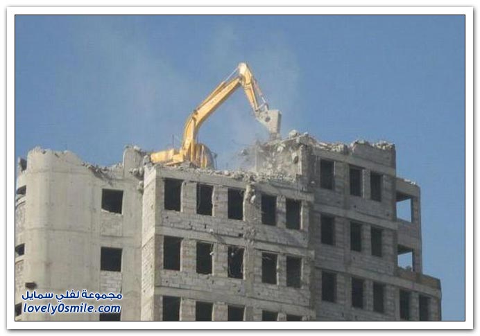 صور حفارة تهدم مبنى من السطوح
