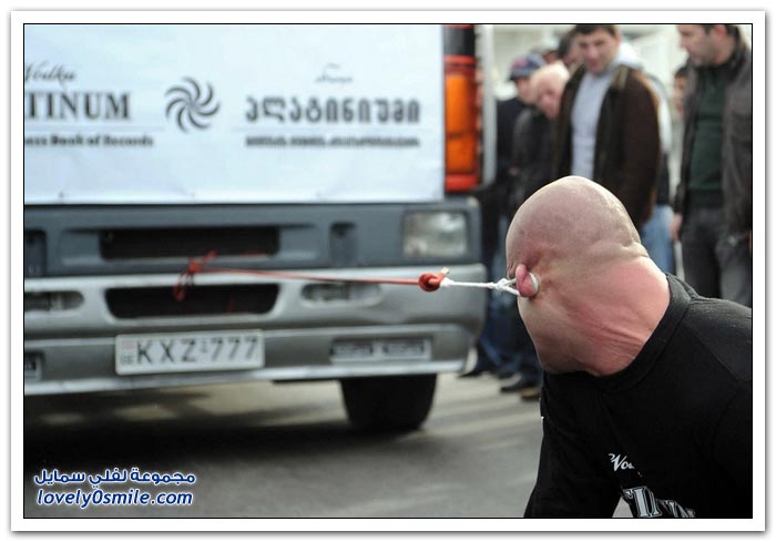 رجل يجر شاحنة بأذنه